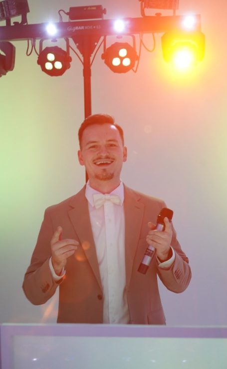 DJ steht an einem Mischpult und konzentriert sich auf seine Musik.